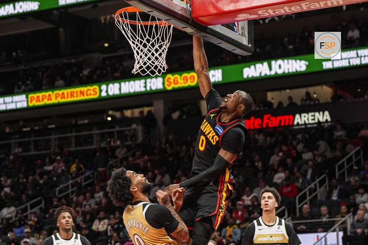 Feb 24, 2026; Atlanta, Georgia, USA; Atlanta Hawks forward Jonathan Kuminga (0)  scores over Washington Wizards forward Justin Champagnie (9) during the second half at State Farm Arena. Credit: Dale Zanine-Imagn Images