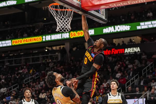 Feb 24, 2026; Atlanta, Georgia, USA; Atlanta Hawks forward Jonathan Kuminga (0)  scores over Washington Wizards forward Justin Champagnie (9) during the second half at State Farm Arena. Mandatory Credit: Dale Zanine-Imagn Images