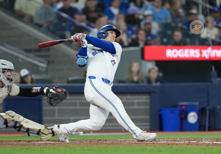 May 18, 2025; Toronto, Ontario, CAN; Toronto Blue Jays centre ielder Daulton Varsho (5) hits a double against the Detroit Tigers during the fourth inning at Rogers Centre. Credit: Nick Turchiaro-Imagn Images