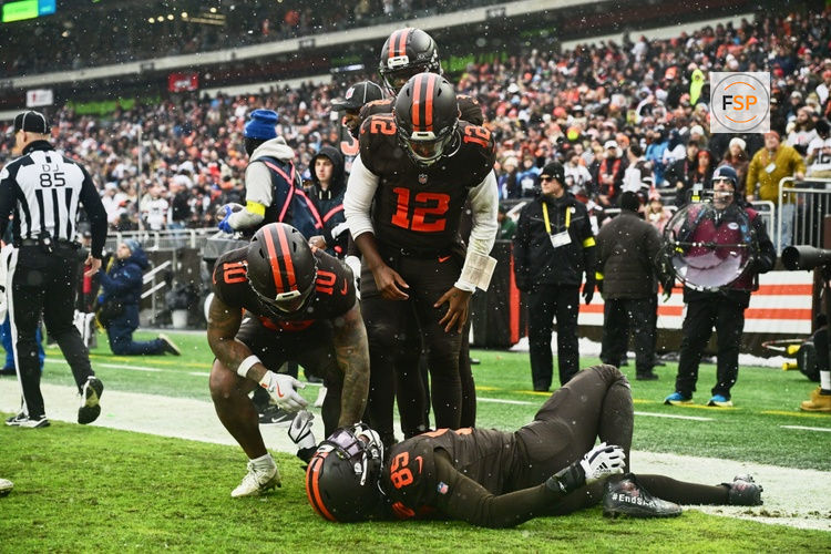 Dec 7, 2025; Cleveland, Ohio, USA;  Cleveland Browns tight end David Njoku (85) lies on the field with an apparent injury after catching a one-yard touchdown pass thrown by quarterback Shedeur Sanders (12)  against the Tennessee Titans and Cleveland Browns running back Quinshon Judkins (10) looks on during the second quarter at Huntington Bank Field. Credit: Ken Blaze-Imagn Images