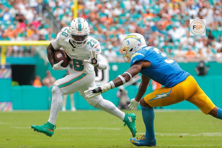 Oct 12, 2025; Miami Gardens, Florida, USA; Miami Dolphins running back De'Von Achane (28) carries the football against Los Angeles Chargers free safety Derwin James (3) during the second quarter at Hard Rock Stadium. Credit: Sam Navarro-Imagn Images
