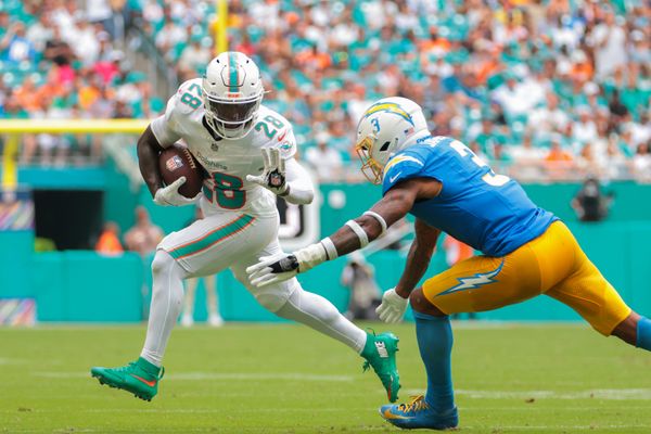 Oct 12, 2025; Miami Gardens, Florida, USA; Miami Dolphins running back De'Von Achane (28) carries the football against Los Angeles Chargers free safety Derwin James (3) during the second quarter at Hard Rock Stadium. Mandatory Credit: Sam Navarro-Imagn Images