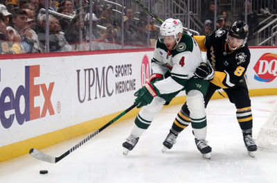 Oct 29, 2024; Pittsburgh, Pennsylvania, USA;  Minnesota Wild defenseman Jon Merrill (4) chases the puck against pressure from Pittsburgh Penguins left wing Michael Bunting (8) during the second period at PPG Paints Arena. Mandatory Credit: Charles LeClaire-Imagn Images