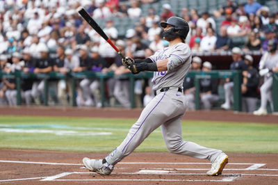 May 17, 2025; Phoenix, Arizona, USA;  Colorado Rockies catcher Hunter Goodman (15) hits a home run against the Arizona Diamondbacks in the first inning at Chase Field. Mandatory Credit: Jacob Reiner-Imagn Images