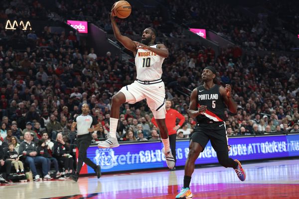 Feb 20, 2026; Portland, Oregon, USA;  Denver Nuggets guard/forward Tim Hardaway Jr. (10) shoots over Portland Trail Blazers guard Jrue Holiday (5) during first half at Moda Center. Mandatory Credit: Jaime Valdez-Imagn Images