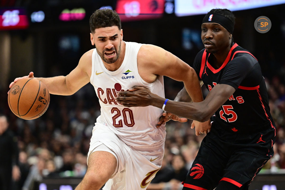 Nov 24, 2024; Cleveland, Ohio, USA; Cleveland Cavaliers forward Georges Niang (20) drives to the basket against Toronto Raptors forward Chris Boucher (25) during the first half at Rocket Mortgage FieldHouse. Credit: Ken Blaze-Imagn Images