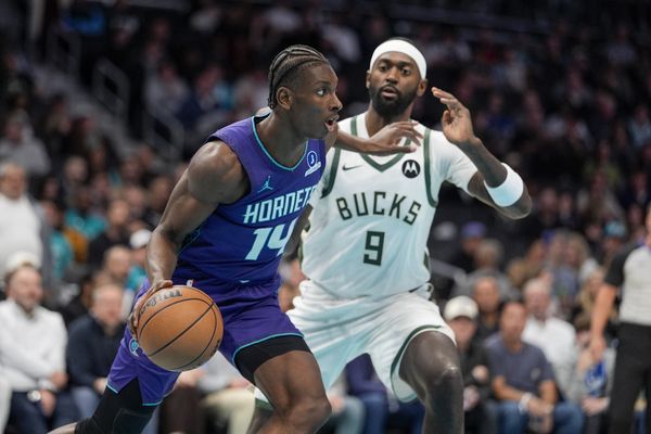 Nov 12, 2025; Charlotte, North Carolina, USA; Charlotte Hornets forward Moussa Diabate (14) looks to pass defended by Milwaukee Bucks forward Bobby Portis (9) during the first quarter at Spectrum Center. Mandatory Credit: Jim Dedmon-Imagn Images