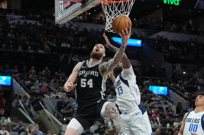 Mar 10, 2025; San Antonio, Texas, USA;  San Antonio Spurs forward Sandro Mamukelashvili (54) shoots against Dallas Mavericks forward Naji Marshall (13) in the first half at Frost Bank Center. Mandatory Credit: Daniel Dunn-Imagn Images