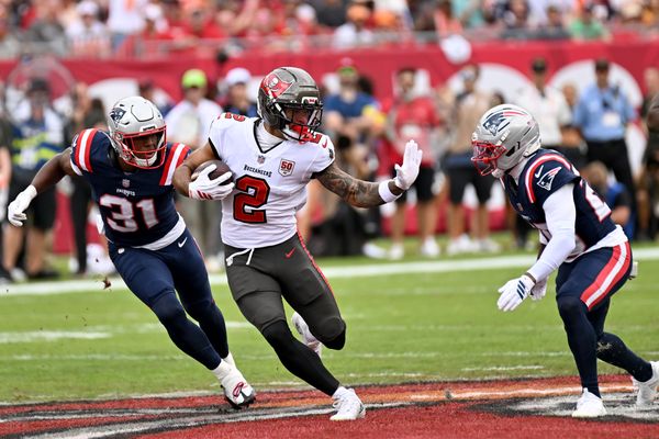 Nov 9, 2025; Tampa, Florida, USA; Tampa Bay Buccaneers wide receiver Emeka Egbuka (2) runs for a gain past New England Patriots safety Craig Woodson (31) and cornerback Marcus Jones (25) during the first quarter at Raymond James Stadium. Mandatory Credit: Jonathan Dyer-Imagn Images