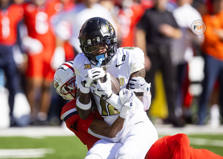 Oct 19, 2024; Tucson, Arizona, USA; Colorado Buffalos wide receiver Travis Hunter (12) is tackled by Arizona Wildcats cornerback Tacario Davis (1) at Arizona Stadium. Credit: Mark J. Rebilas-Imagn Images