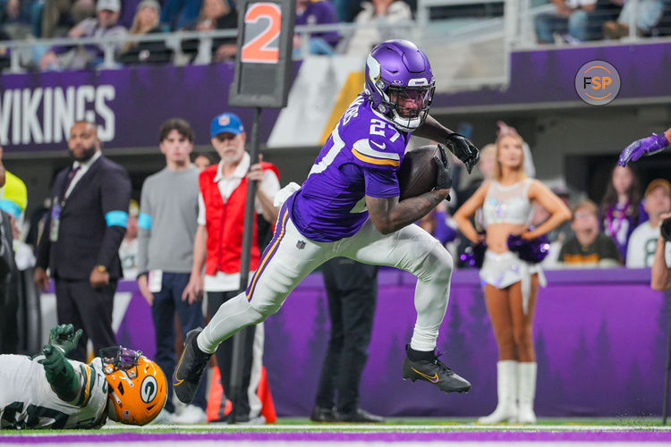 Dec 29, 2024; Minneapolis, Minnesota, USA; Minnesota Vikings running back Cam Akers (27) scores a touchdown against Green Bay Packers in the third quarter at U.S. Bank Stadium. Credit: Brad Rempel-Imagn Images