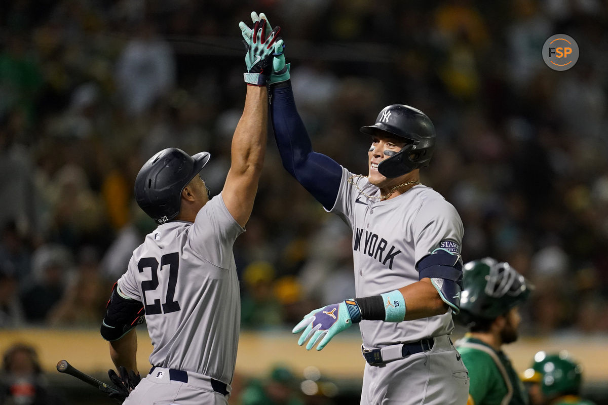 Sep 21, 2024; Oakland, California, USA; New York Yankees outfielder Aaron Judge (99) is congratulated by designated hitter Giancarlo Stanton (27) after hitting a home run against the Oakland Athletics in the seventh inning at the Oakland-Alameda County Coliseum. Credit: Cary Edmondson-Imagn Images