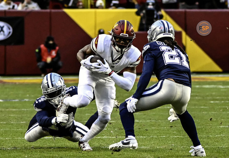 LANDOVER, MD - JANUARY 07: Washington Commanders wide receiver Terry McLaurin (17)  makes a pass reception and is brought down by Dallas Cowboys safety Markquese Bell (14) and cornerback Stephon Gilmore (21) during the NFL game between the Dallas Cowboys and the Washington Commanders on January 7, 2024 at Fed Ex Field in Landover, MD. (Photo by Mark Goldman/Icon Sportswire)