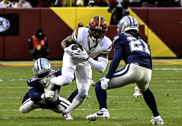 LANDOVER, MD - JANUARY 07: Washington Commanders wide receiver Terry McLaurin (17)  makes a pass reception and is brought down by Dallas Cowboys safety Markquese Bell (14) and cornerback Stephon Gilmore (21) during the NFL game between the Dallas Cowboys and the Washington Commanders on January 7, 2024 at Fed Ex Field in Landover, MD. (Photo by Mark Goldman/Icon Sportswire)