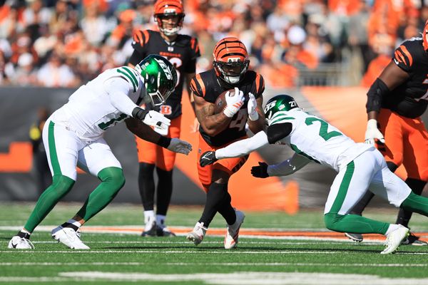 Oct 26, 2025; Cincinnati, Ohio, USA; Cincinnati Bengals running back Samaje Perine (34) escapes attack by safety Malachi Moore (27) and linebacker Jermaine Johnson (11) during the second quarter at Paycor Stadium. Mandatory Credit: Katie Stratman-Imagn Images