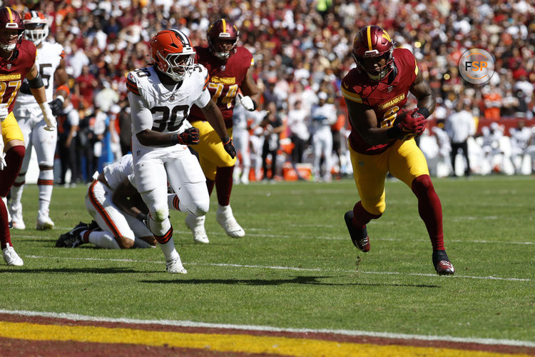 Oct 6, 2024; Landover, Maryland, USA; Washington Commanders running back Brian Robinson Jr. (8) carries the ball past Cleveland Browns linebacker Devin Bush (30) to score a touchdown during the first quarter at NorthWest Stadium. Credit: Geoff Burke-Imagn Images