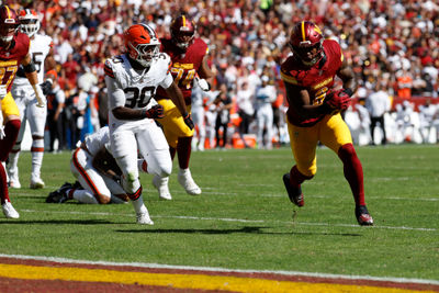 Oct 6, 2024; Landover, Maryland, USA; Washington Commanders running back Brian Robinson Jr. (8) carries the ball past Cleveland Browns linebacker Devin Bush (30) to score a touchdown during the first quarter at NorthWest Stadium. Mandatory Credit: Geoff Burke-Imagn Images