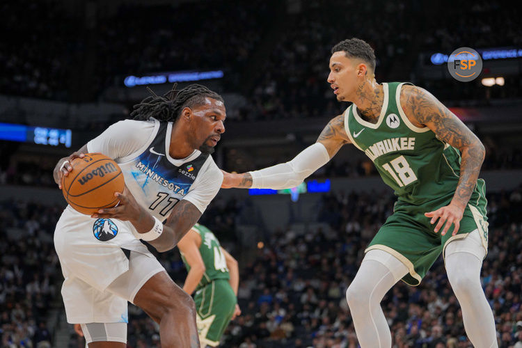 Feb 12, 2025; Minneapolis, Minnesota, USA; Minnesota Timberwolves center Naz Reid (11) dribbles against the Milwaukee Bucks forward Kyle Kuzma (18) in the first quarter at Target Center. Credit: Brad Rempel-Imagn Images