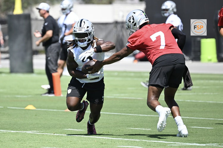 Jun 10, 2025; Henderson, NV, USA; Las Vegas Raiders quarterback Geno Smith (7) hands the ball off to running back Ashton Jeanty (2) during Las Vegas Raiders Minicamp at Intermountain Health Performance Center. Credit: Candice Ward-Imagn Images