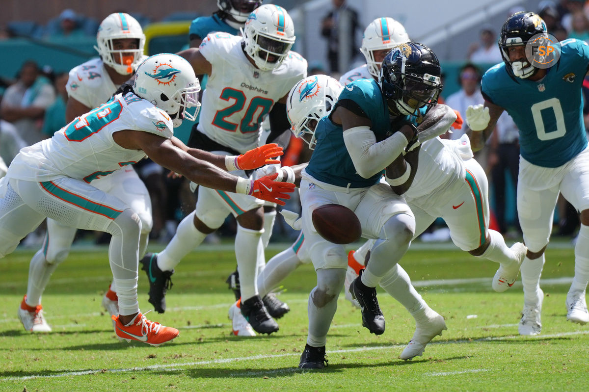 Sep 8, 2024; Miami Gardens, Florida, USA;  Miami Dolphins safety Jevon Holland (8) punches the ball away from Jacksonville Jaguars running back Travis Etienne Jr. (1) causing a fumble that was recovered by the Dolphins in the end zone during the third quarter at Hard Rock Stadium. Credit: Jim Rassol-Imagn Images