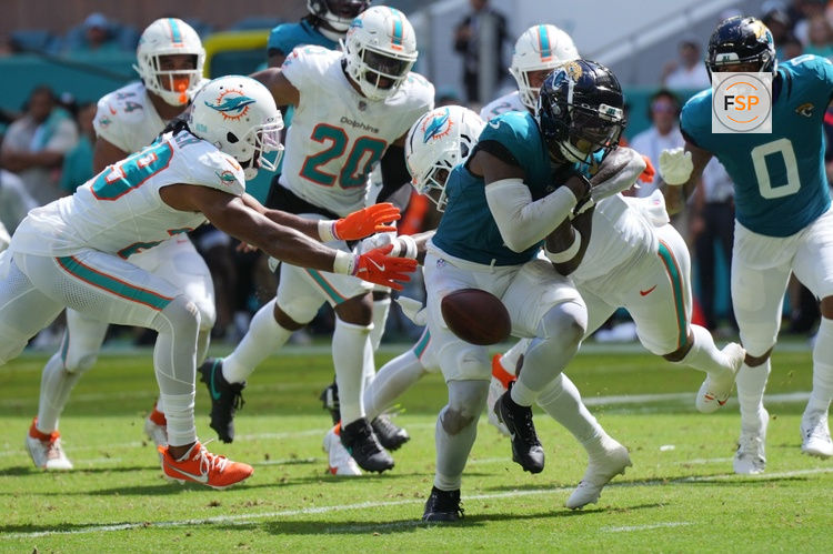 Sep 8, 2024; Miami Gardens, Florida, USA;  Miami Dolphins safety Jevon Holland (8) punches the ball away from Jacksonville Jaguars running back Travis Etienne Jr. (1) causing a fumble that was recovered by the Dolphins in the end zone during the third quarter at Hard Rock Stadium. Credit: Jim Rassol-Imagn Images