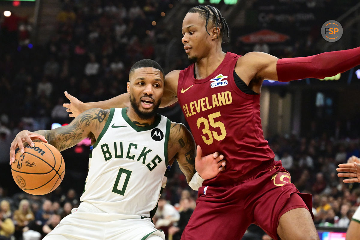 Nov 4, 2024; Cleveland, Ohio, USA; Milwaukee Bucks guard Damian Lillard (0) drives to the basket against Cleveland Cavaliers forward Isaac Okoro (35) during the first quarter at Rocket Mortgage FieldHouse. Credit: Ken Blaze-Imagn Images