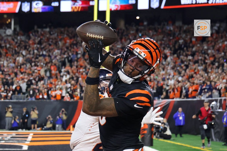 Dec 28, 2024; Cincinnati, Ohio, USA;  Cincinnati Bengals  wide receiver Tee Higgins (5) catches a touchdown as Denver Broncos cornerback Riley Moss (21) defends during the fourth quarter at Paycor Stadium. Credit: Joseph Maiorana-Imagn Images