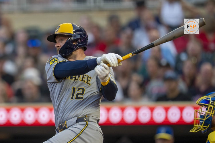 Jun 20, 2025; Minneapolis, Minnesota, USA; Milwaukee Brewers first baseman Rhys Hoskins (12) hits a single against the Minnesota Twins in the fifth inning at Target Field. Credit: Jesse Johnson-Imagn Images