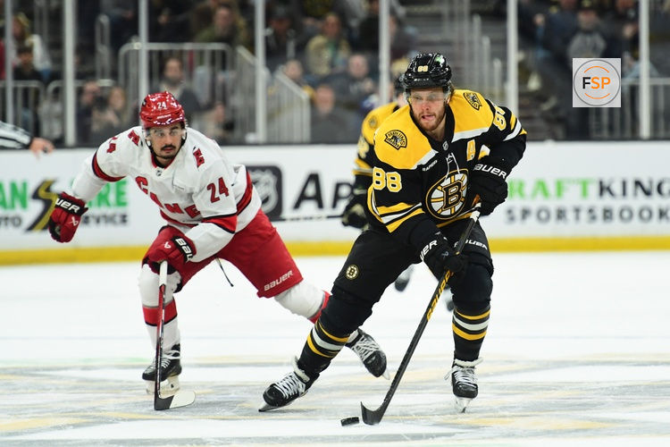 Apr 5, 2025; Boston, Massachusetts, USA; Boston Bruins right wing David Pastrnak (88) skates the puck ahead of Carolina Hurricanes center Seth Jarvis (24) during the first period at TD Garden. Credit: Bob DeChiara-Imagn Images