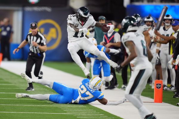 Dec 8, 2025; Inglewood, California, USA; Philadelphia Eagles wide receiver A.J. Brown (11) hurdles Los Angeles Chargers safety RJ Mickens (27) in the second half at SoFi Stadium. Mandatory Credit: Kirby Lee-Imagn Images