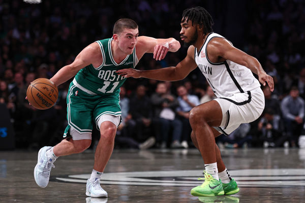 Nov 13, 2024; Brooklyn, New York, USA; Boston Celtics guard Payton Pritchard (11) dribbles as Brooklyn Nets guard Cam Thomas (24) defends during the first half at Barclays Center. Mandatory Credit: Vincent Carchietta-Imagn Images