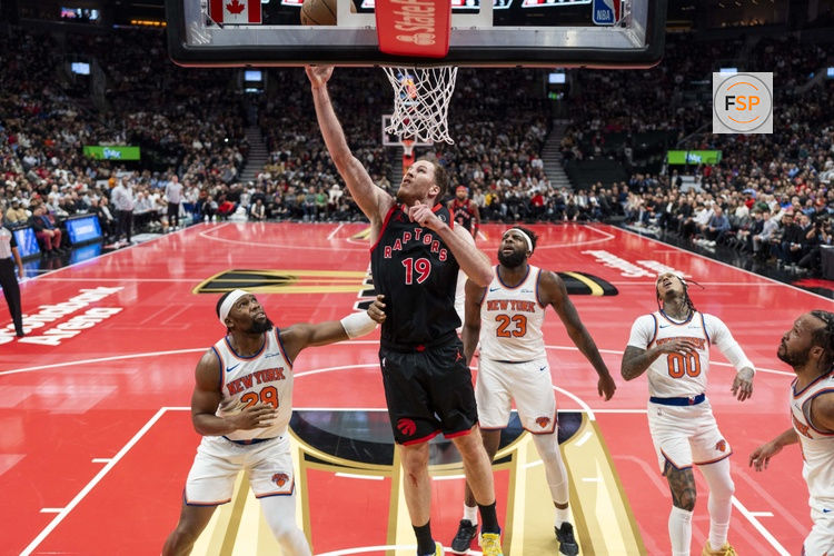 Dec 9, 2025; Toronto, Ontario, CAN;  Toronto Raptors center Jakob Poeltl (19) drives to the basket during the first half against the New York Knicks at the 2025-26 NBA Emirates Cup at Scotiabank Arena. Credit: Kevin Sousa-Imagn Images