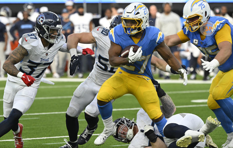 Nov 10, 2024; Inglewood, California, USA; Los Angeles Chargers running back J.K. Dobbins (27) tries to break free from Tennessee Titans defensive tackle James Lynch (on the ground), safety Amani Hooker (37) and Tennessee Titans linebacker Jack Gibbens (50) during the seconds quarter at SoFi Stadium. Credit: Robert Hanashiro-Imagn Images