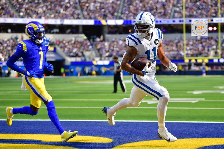 Sep 28, 2025; Inglewood, California, USA; Indianapolis Colts wide receiver Michael Pittman (11) scores a touchdown ahead of Los Angeles Rams cornerback Emmanuel Forbes Jr. (1) during the second half at SoFi Stadium. Credit: Gary A. Vasquez-Imagn Images