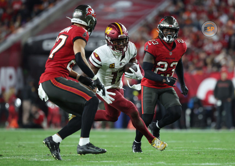 Jan 12, 2025; Tampa, Florida, USA; Washington Commanders wide receiver Terry McLaurin (17) runs against Tampa Bay Buccaneers cornerback Zyon McCollum (27) and safety Tykee Smith (23) during the fourth quarter of a NFC wild card playoff at Raymond James Stadium. Credit: Kim Klement Neitzel-Imagn Images