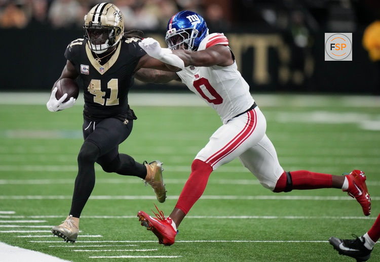 Oct 5, 2025; New Orleans, Louisiana, USA; New Orleans Saints running back Alvin Kamara (41) runs the ball against New York Giants linebacker Brian Burns (0) at Caesars Superdome. Credit: Matthew Hinton-Imagn Images