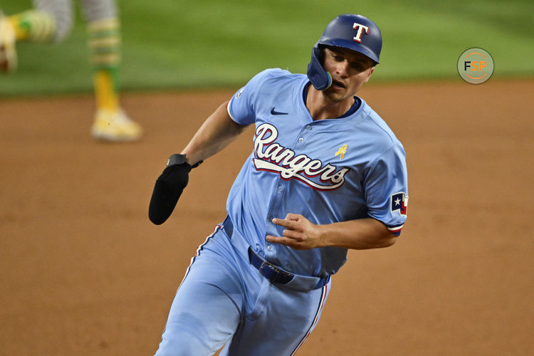 Sep 1, 2024; Arlington, Texas, USA; Texas Rangers shortstop Corey Seager (5) scores from second base on a double hit by right fielder Adolis Garcia (not pictured) during the first inning at Globe Life Field. Credit: Jerome Miron-USA TODAY Sports