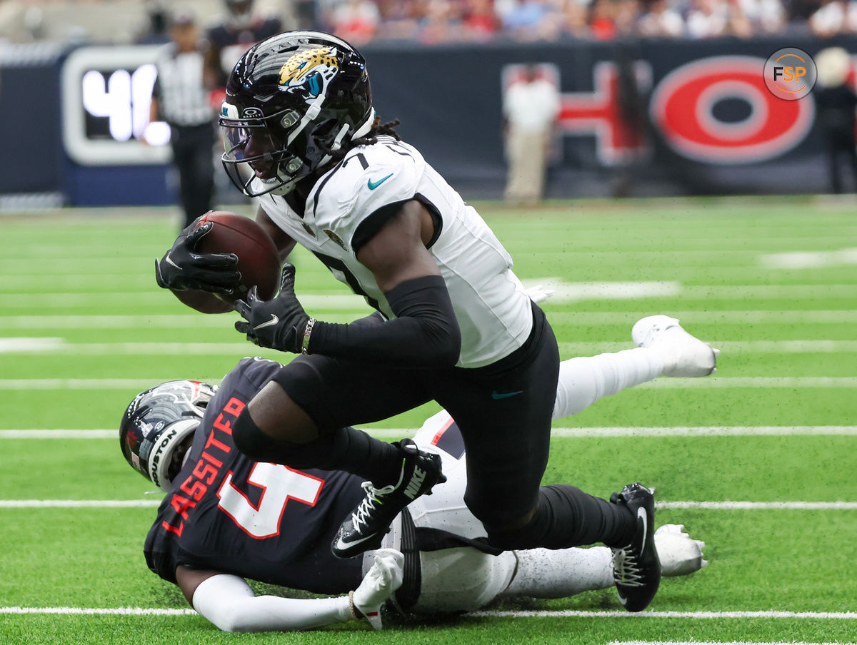 Sep 29, 2024; Houston, Texas, USA; Jacksonville Jaguars wide receiver Brian Thomas Jr. (7) is tackled by Houston Texans cornerback Kamari Lassiter (4) in the second half at NRG Stadium. Credit: Thomas Shea-Imagn Images