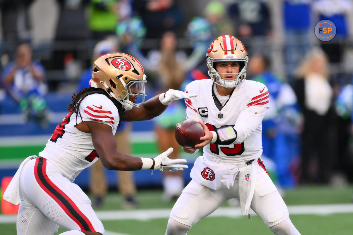 Oct 10, 2024; Seattle, Washington, USA; San Francisco 49ers quarterback Brock Purdy (13) hands the ball off to running back Jordan Mason (24) during the first half against the Seattle Seahawks at Lumen Field. Credit: Steven Bisig-Imagn Images