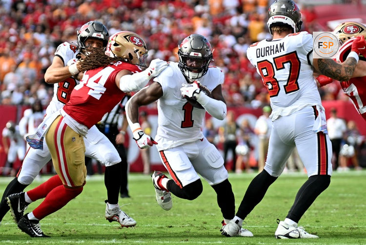 Oct 12, 2025; Tampa, Florida, USA; Tampa Bay Buccaneers running back Rachaad White (1) runs for a gain past San Francisco 49ers middle linebacker Fred Warner (54) during the first quarter at Raymond James Stadium. Credit: Jonathan Dyer-Imagn Images