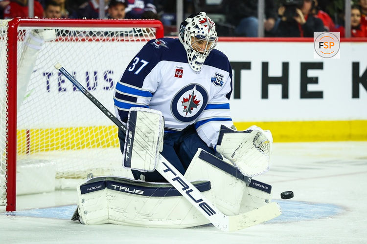 Nov 15, 2025; Calgary, Alberta, CAN; Winnipeg Jets goaltender Connor Hellebuyck (37) makes a save against the Calgary Flames during the second period at Scotiabank Saddledome. Credit: Sergei Belski-Imagn Images