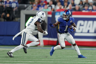 Sep 26, 2024; East Rutherford, New Jersey, USA; New York Giants wide receiver Malik Nabers (1) runs with the ball against Dallas Cowboys cornerback Jourdan Lewis (2) during the fourth quarter at MetLife Stadium. Mandatory Credit: Brad Penner-Imagn Images