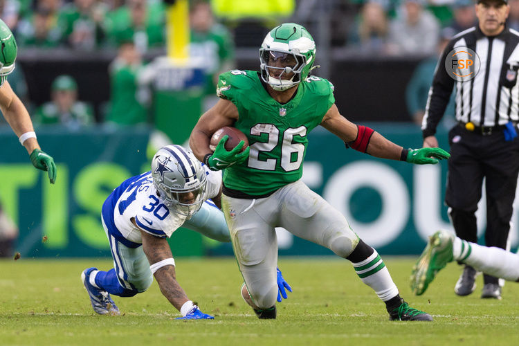 Dec 29, 2024; Philadelphia, Pennsylvania, USA; Philadelphia Eagles running back Saquon Barkley (26) runs with the ball past Dallas Cowboys safety Juanyeh Thomas (30) at Lincoln Financial Field. Credit: Bill Streicher-Imagn Images