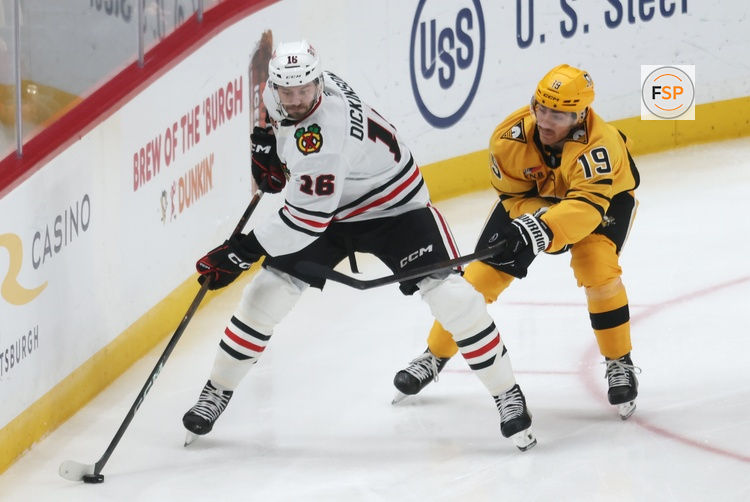 Jan 29, 2026; Pittsburgh, Pennsylvania, USA;  Chicago Blackhawks center Jason Dickinson (16) moves the puck against Pittsburgh Penguins center Blake Lizotte (46) during the third period at PPG Paints Arena. Credit: Charles LeClaire-Imagn Images