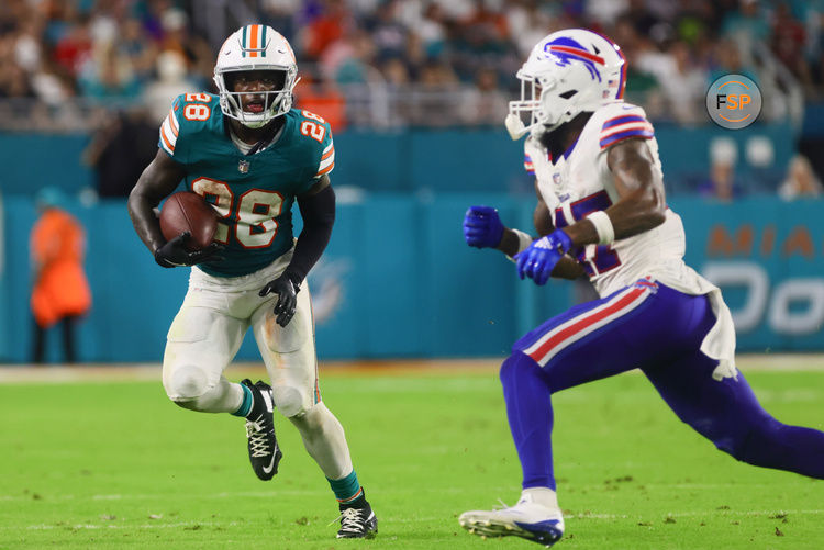 Sep 12, 2024; Miami Gardens, Florida, USA; Miami Dolphins running back De'Von Achane (28) runs with the football against Buffalo Bills cornerback Christian Benford (47) during the second quarter at Hard Rock Stadium. Credit: Sam Navarro-Imagn Images